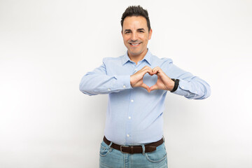 Smiling man showing heart gesture