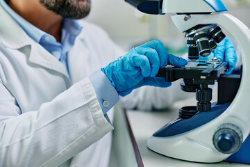 Wall Mural - close up of lab technician preparing medical sample for research under microscope.