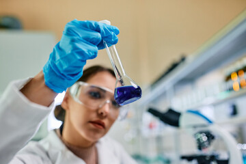 Wall Mural - close up of female scientist analyzing chemical substance while working in lab.