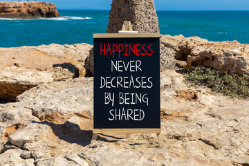 Wall Mural - Happiness symbol. Concept words Happiness never decreases by being shared on beautiful black chalkboard. Beautiful stone sea background. Motivational Happiness concept. Copy space.