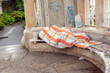 A homeless man in one of the parks of the city of Vienna sleeps on a bench.