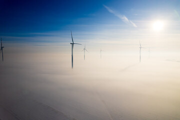 Aerial view of windfarm during winter foggy morning
