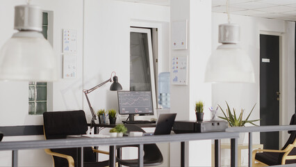 Wall Mural - Professional corporation workstations with multiple desks, empty open space filled with boardroom business equipment and computers. Digital agency workspace in corporate interior.