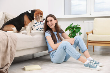 Canvas Print - Happy young woman with her cute Beagle dog at home. Lovely pet