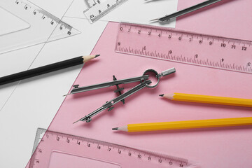 Wall Mural - Different rulers, pencils and compass on pink background, above view