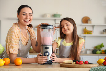 Sticker - Little girl and her mother making smoothie with blender in kitchen