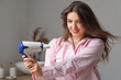 © Pixel-Shot - Pretty young woman with hair dryer in bathroom