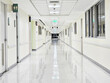 © Chatchaa - Long hospital bright corridor with rooms. Empty modern hospital corridor.