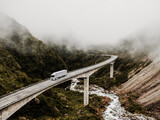 Fototapeta  - Semi-Truck and Trailer Crossing Majestic Mountain Bridge