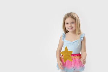 Wall Mural - Studio portrait of beautiful little princess holding star shaped magic wand	