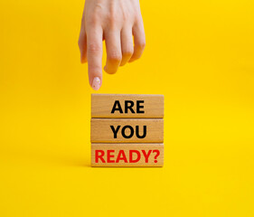 Wall Mural - Are you ready symbol. Concept word Are you ready on wooden blocks. Businessman hand. Beautiful yellow background. Business and Are you ready concept. Copy space