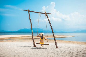 Traveler asian woman relax and travel in swing on summer beach at Koh Rap Samui in Surat Thani Thailand