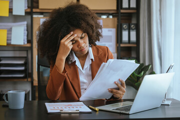 Wall Mural - Tired african american business woman working with audit, balance sheet, investing activities, safety stock, net loss, business risks, accumulated depreciation, factory overhead, accrued expense