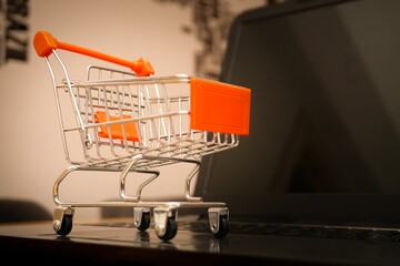 Wall Mural - Miniature shopping cart on a laptop - online shopping concept