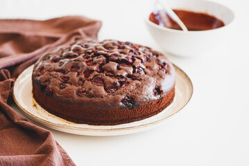 Wall Mural - Delicious chocolate cake brownie with cherries on white wooden table