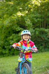 Wall Mural - Happy kid boy, having fun in park with a bicycle on beautiful day. Active child wearing bike helmet