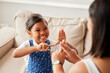 © Alexis Scholtz/peopleimages.com - Sign language, learning and girl kid with her mother in the living room of their family home. Happy, smile and child speaking with her hands to her deaf mom to communicate in their modern house.
