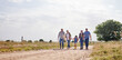 © N Lawrenson/peopleimages.com - Love, happy family walking holding hands and on a farm with blue sky. Support or care, happiness or agriculture and people walk outdoors by countryside or rural environment together with generation