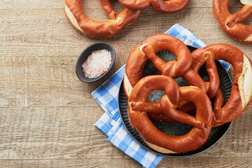 Wall Mural - Oktoberfest concept card. Traditional Bavarian pretzels with beer bottle mug on old rustic wooden background. Perfect for Octoberfest. Oktoberfest food menu. Top view. Mock up.