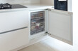 Opened build-in freezer in a light bright kitchen