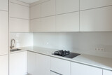 Fototapeta Tulipany - Close-up of the work area in the kitchen with an ultra-thin countertop and glass backsplash
