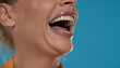 Porcelain teeth in female open smiling mouth on a blue background
