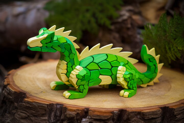 Sticker - Green dragon figurine sitting on top of piece of wood. Generative AI.