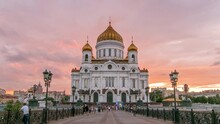 Majestic Orthodox Cathedral Of Christ Saviour With Sunset On Bank Of Moscow River. It Is Tallest Orthodox Church In World. Orange Sky With Clouds. Timelapse From The Patriarchal Bridge, Russia