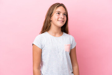 Wall Mural - Little caucasian girl isolated on pink background thinking an idea while looking up