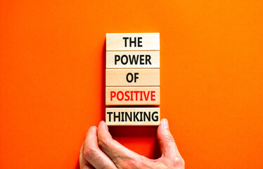 Positive thinking symbol. Concept words The power of positive thinking on wooden block. Beautiful orange background. Businessman hand. Business, motivational positive thinking concept. Copy space.