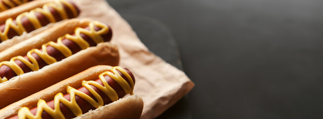 Wall Mural - Barbecue Grilled Hot Dogs with  yellow American mustard, On a dark wooden background