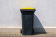 Yellow dustbin or trash can or black dustbin or trash can with yellow lid