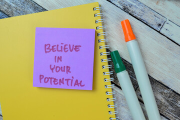 Concept of Believe in Your Potential write on sticky notes isolated on Wooden Table.