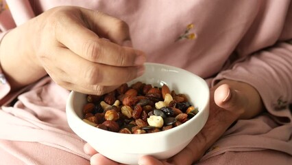 Wall Mural - women hand pick mixed nut from a bowl 