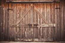  A Barn Door With A Wooden Frame On A Wooden Building With A Horse Standing In Front Of The Door And Looking At The Camera Man In The Distance.  Generative Ai