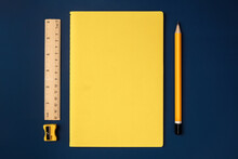 Top View Pastel Yellow Notebook With Yellow Pencil And Notepad On Navy Blue Working Table