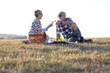 © pucko_ns - Charming senior couple enjoying a delightful picnic in the great outdoors. They are seen lounging comfortably on a checked blanket