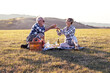 © pucko_ns - Charming senior couple enjoying a delightful picnic in the great outdoors. They are seen lounging comfortably on a checked blanket