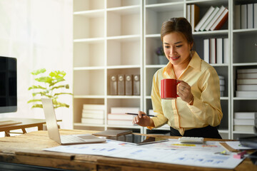 Wall Mural - Attractive millennial woman entrepreneur working on new business strategy at contemporary office