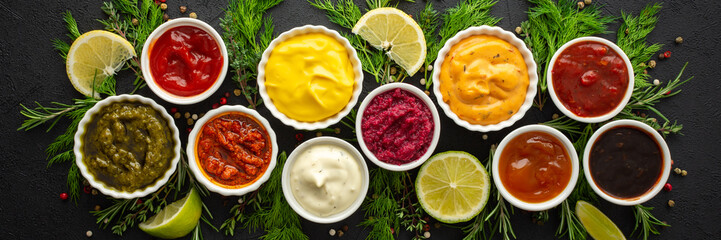 Different types of sauces in bowls with seasonings banner, rosemary and dill, thyme and and peppercorns, top view, copy space