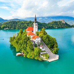 Canvas Print - Church and Castle in Lake Bled, Slovenia with mountains and lush trees in the background