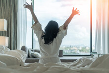 Hotel Relaxation On Lazy Day With Asian Woman Waking Up From Good Sleep On Bed In Weekend Morning Resting In Comfort Bedroom Celebrating Having Happy Work-life Quality Balance Lifestyle