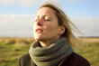 © Leon Waltz - Close-up portrait photography of a woman in her 30s practicing mindfulness sophrology relaxation & stress-reduction wearing a cozy sweater against a countryside or rural landscape background