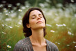 © Leon Waltz - Medium shot portrait photography of a woman in her 30s practicing mindfulness sophrology relaxation & stress-reduction wearing a cozy sweater against a floral meadow background