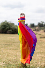 Pride flag hanging from a pole with an arrow indicating the direction to follow