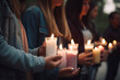Unrecognizable group of friends holding candles during a vigil or memorial service symbolizing remembrance support and solidarity during times of grief or loss,