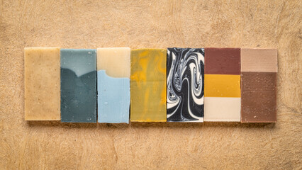 variety of 7 organic, artisan soap bars on a textured bark paper