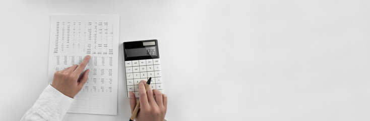 Poster - Woman using a calculator and points her finger at the numbers in the financial documents. Financial,business and money concept. Top view.