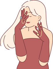 elegant woman in evening dress covers face with hands, wanting to show off gold rings and jewelry