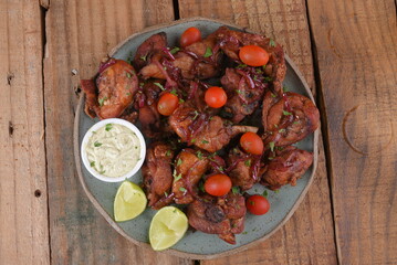 Wall Mural - fried chicken with tomatoes and caramelized onions wings with herb sauce